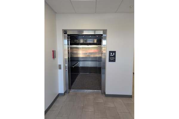 A silver elevator with a black sign on the wall.
